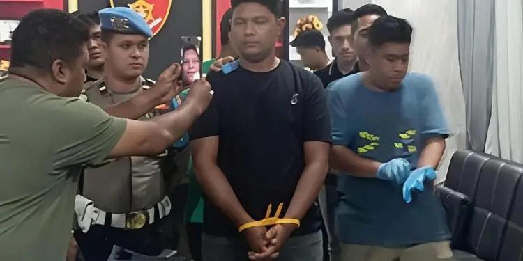 Un policier braque une bijouterie à Aceh Selatan en Indonésie avec une arme longue.